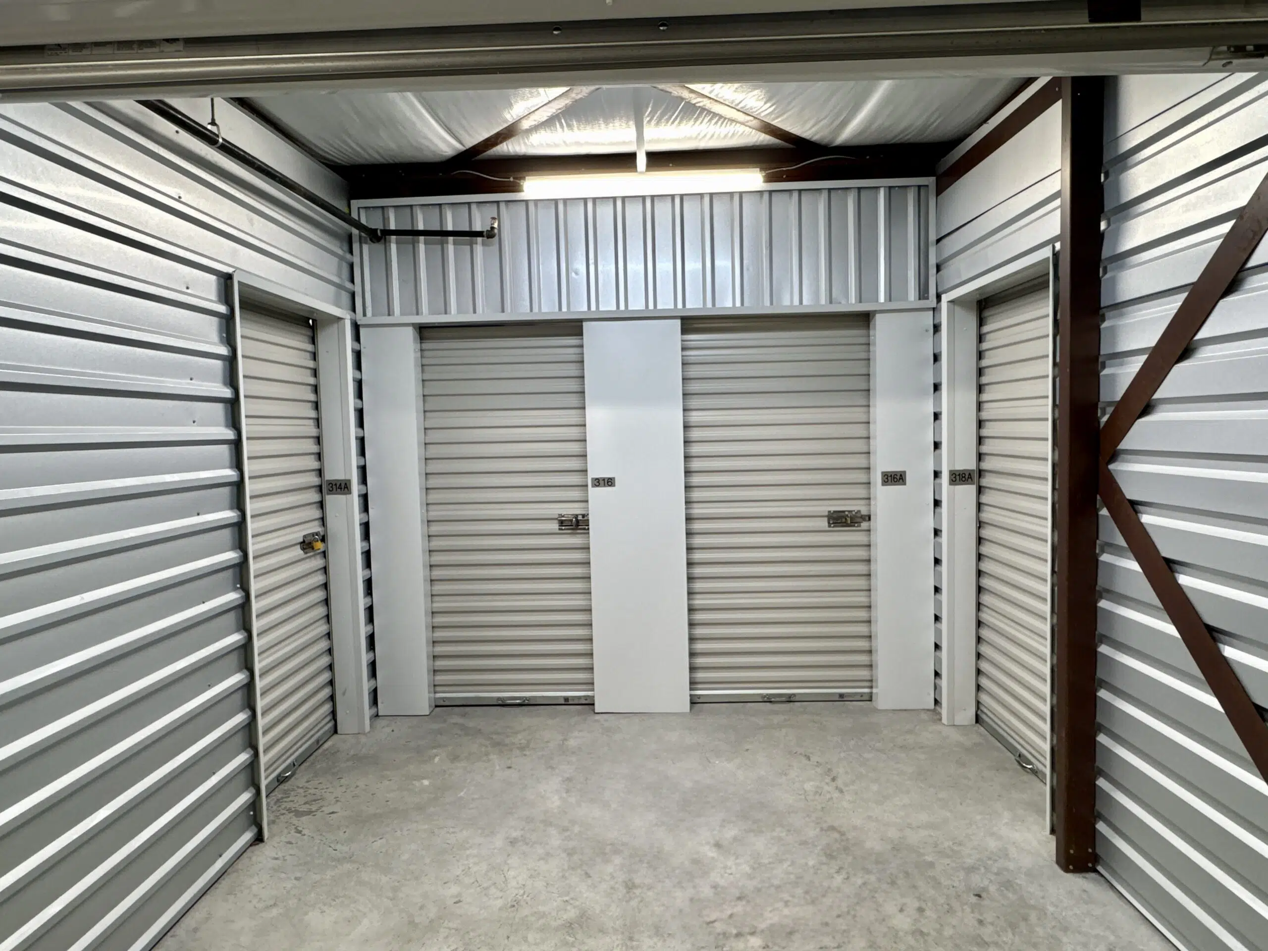 Clean, well-lit hallway of indoor climate-controlled storage units at Storage Solutions Plus.