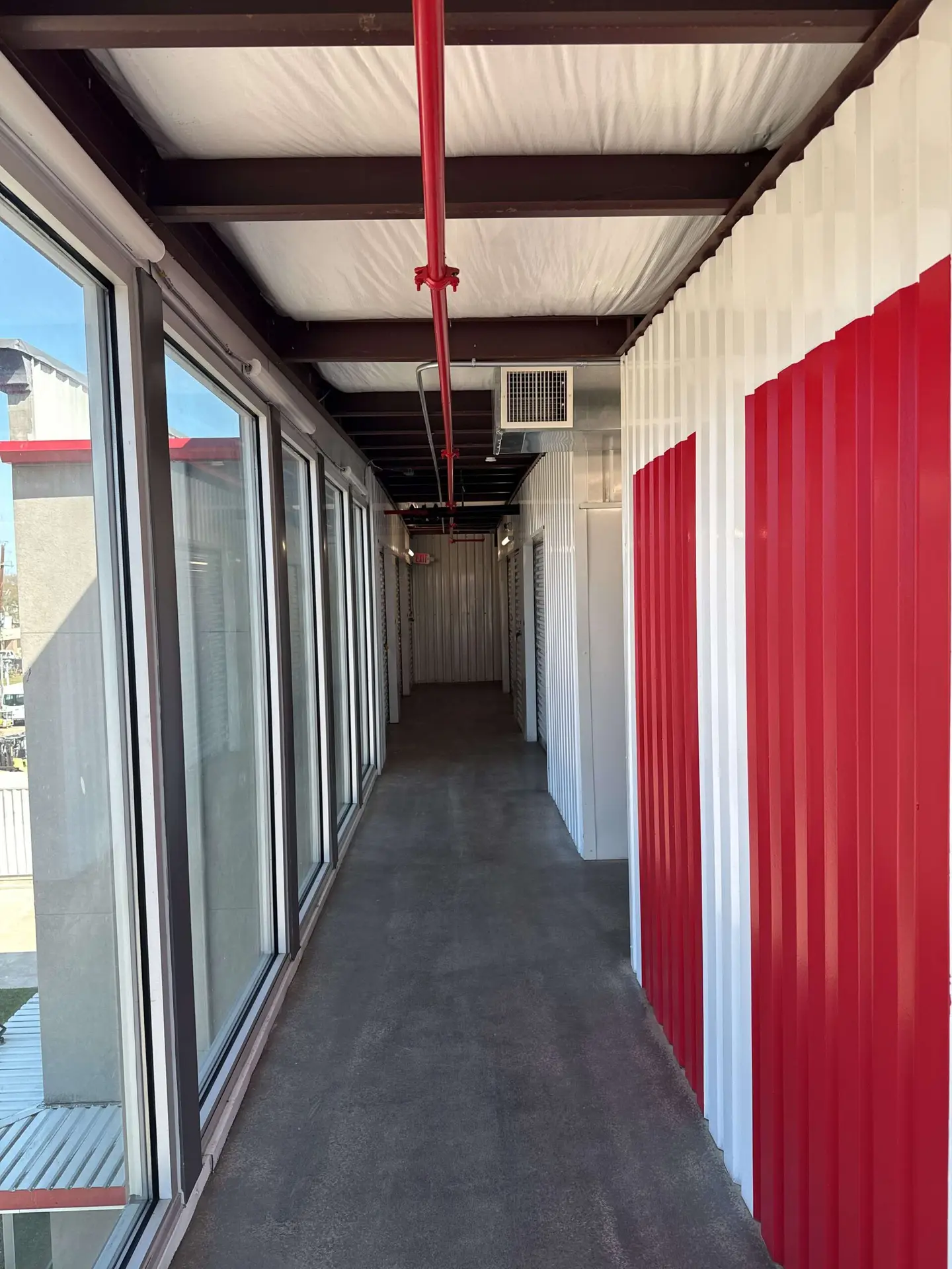 Clean, well-lit hallway of indoor climate-controlled storage units at Storage Solutions Plus.