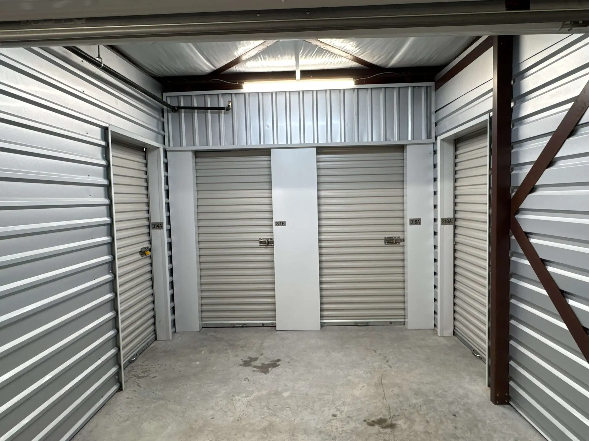 Climate-controlled storage hallway with roll-up unit doors at Tower Oaks