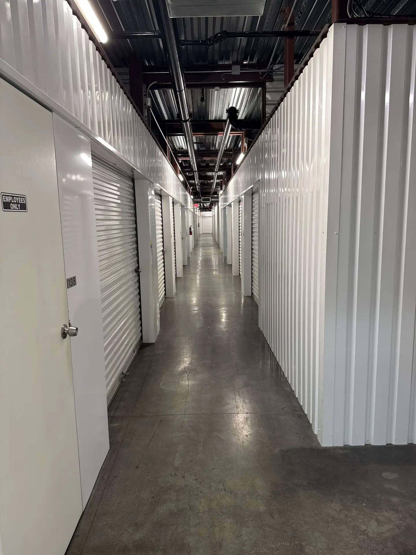 Clean, well-lit hallway of indoor climate-controlled storage units at Storage Solutions Plus.