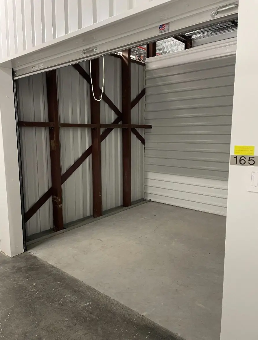 Clean, well-lit hallway of indoor climate-controlled storage units at Storage Solutions Plus.